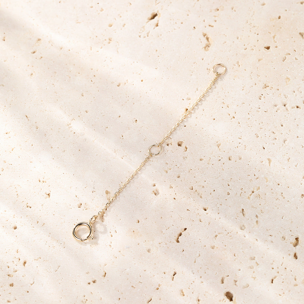 Gold bracelet on a textured beige surface