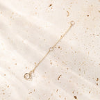 Gold bracelet on a textured beige surface