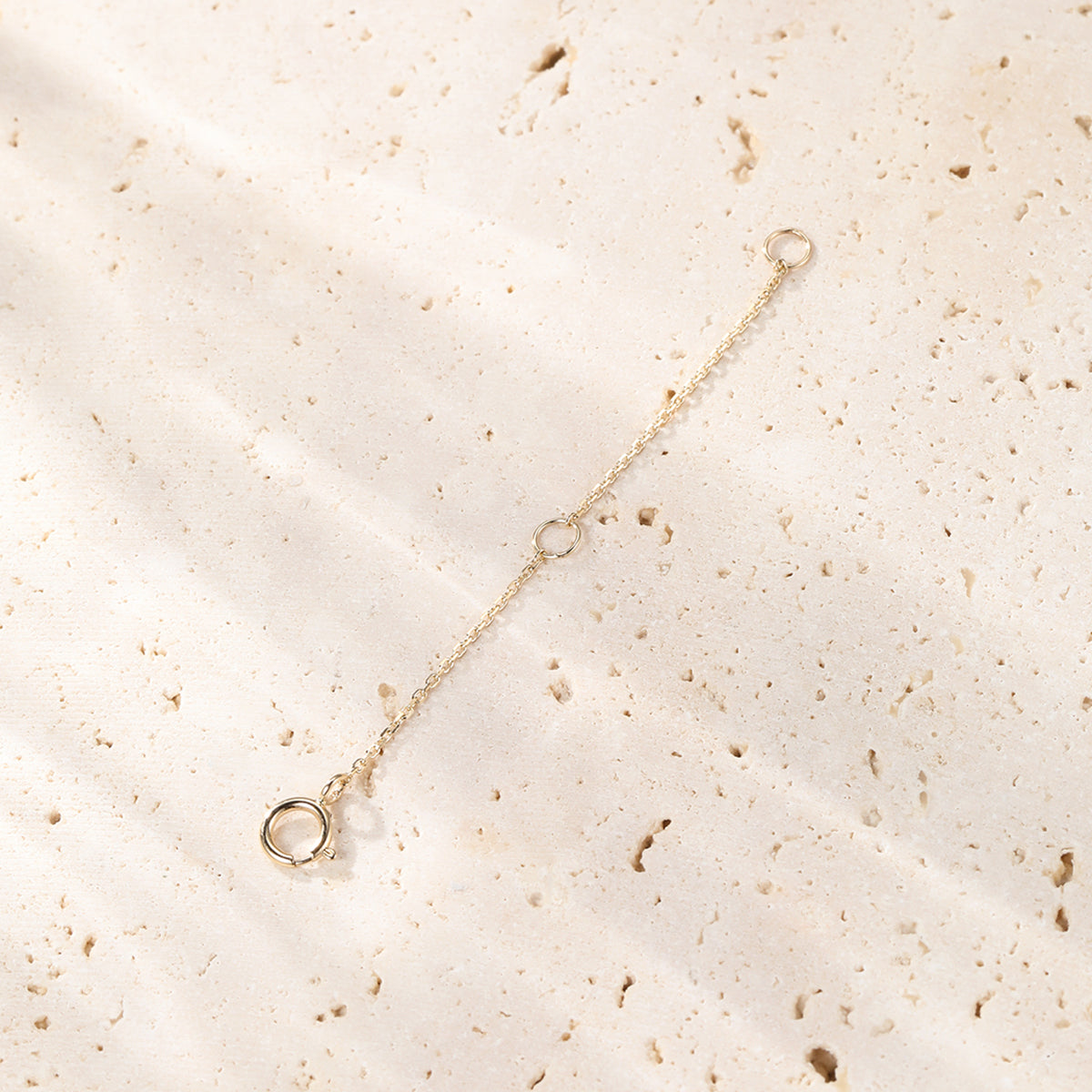 Gold bracelet on a textured beige surface