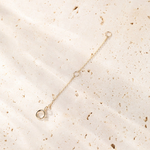 Gold bracelet on a textured beige surface